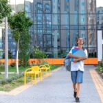 Ecolière avec un cahier dans les mains coucher de soleil sur fond d'école va à l'école. meilleures universités privées en France