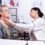 Jeune médecin palpant le cou d'une femme âgée, patient âgé visitant un médecin à l'hôpital, vérifiant la thyroïde, la gorge et touchant la santé à la clinique. Spécialiste de la santé, de l'assurance-maladie, du traitement, concept médical. meilleurs endocrinologues de France