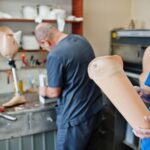 Deux ouvriers prothésistes fabriquent une prothèse de jambe en travaillant dans un laboratoire. meilleurs orthopédistes du genou