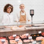 Des employés de magasin posant derrière le comptoir. meilleures boucheries de France