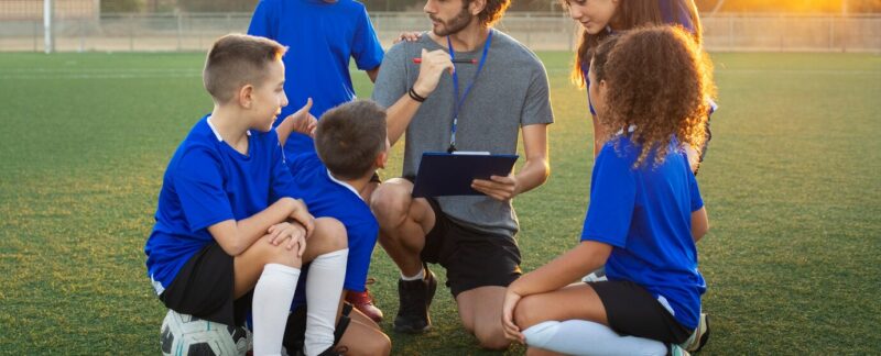 Entraîneur de football enseignant à des enfants, vue de face. meilleures écoles de football en France