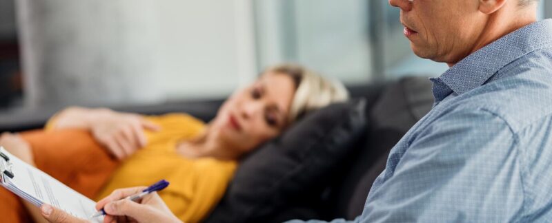 Psychiatre homme prenant des notes tout en conseillant un patient dans son bureau. meilleurs psychiatres de France