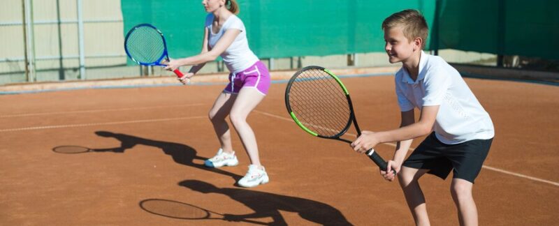 Femme et enfant jouant au tennis. Les meilleures écoles de tennis en France