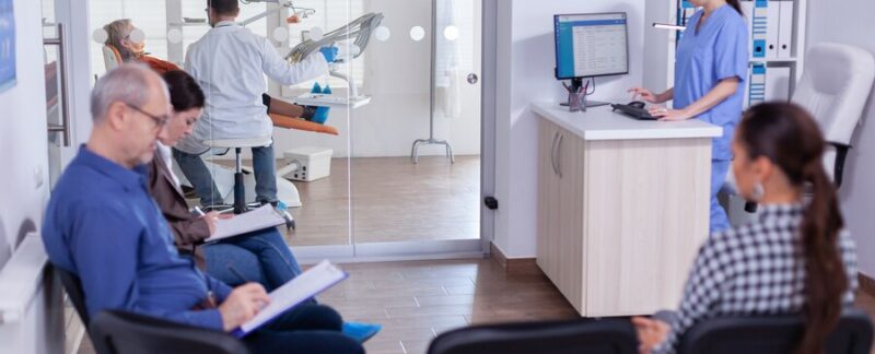 Salle d'attente de stomatologie bondée avec des personnes remplissant un formulaire pour une consultation dentaire. meilleurs centres de traitement de l'ostéoporose en France