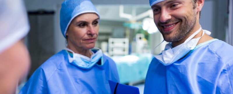 Chirurgiens discutant du dossier d'un patient en salle d'opération. Les meilleurs chirurgiens thoraciques en France