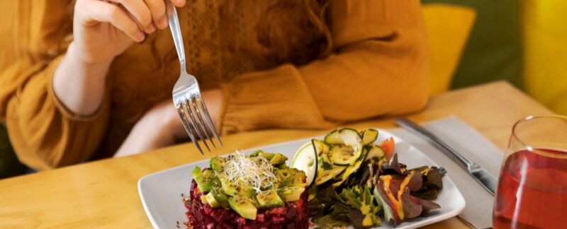 Les meilleurs restaurants végétariens de France. Gros plan d'une main tenant une fourchette