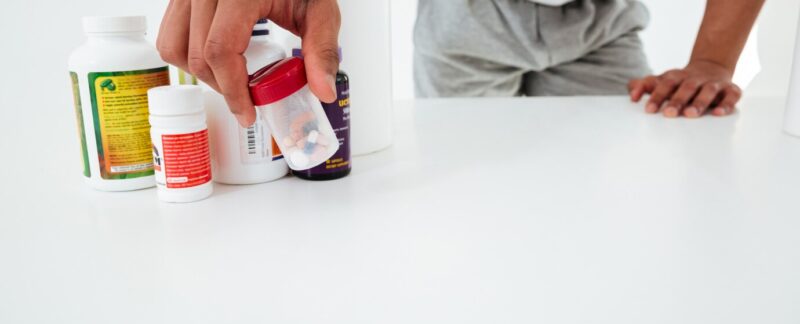 Image recadrée d'un beau jeune sportif tenant des vitamines. Top 10 des Pharmacies Homéopathiques en France