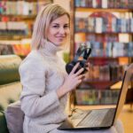 Femme tenant des écouteurs et regardant loin de son ordinateur portable. meilleurs magasins d'informatique en France
