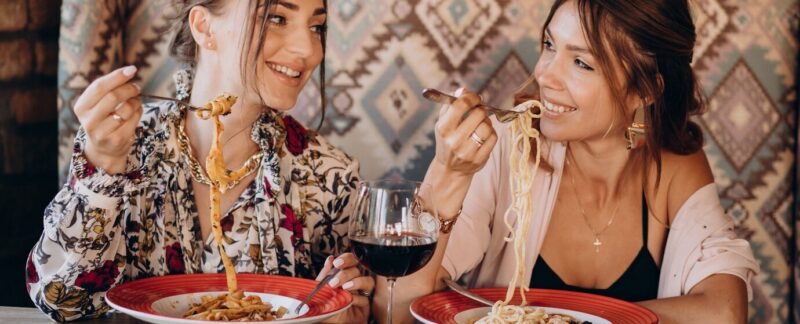 Deux amis mangeant des pâtes dans un restaurant italien. meilleurs restaurants italiens en France