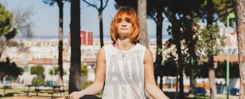 Femme aux cheveux roux méditant dans un parc. Les 10 meilleurs endroits pour pratiquer le yoga en France