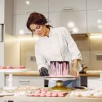 Le pâtissier en uniforme décore le gâteau. Les meilleures écoles de pâtisserie en France