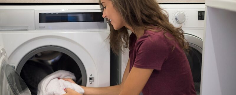Femme mettant en marche une machine à laver. meilleures entreprises de réparation de lave-linge en France