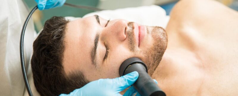 Gros plan d'un beau jeune homme bénéficiant d'une thérapie de rajeunissement du visage dans une station thermale. meilleurs centres d'épilation laser pour hommes en France