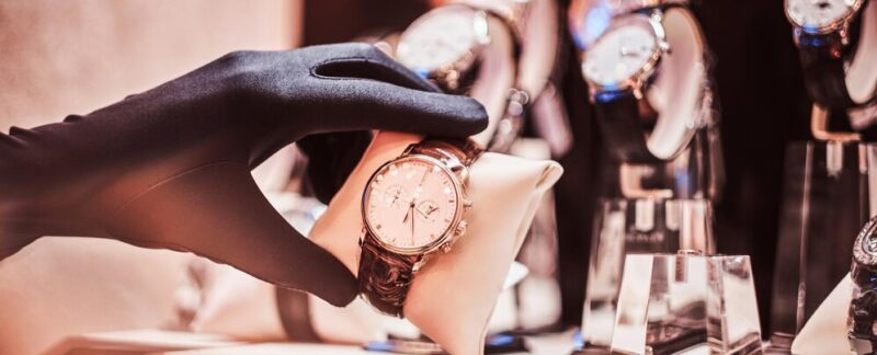 Un gros plan de la main du vendeur dans les gants montre l'exclusivité des vêtements pour hommes. meilleurs magasins de montres en France