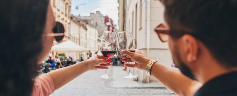 Gros plan sur les mains d'un couple trinquant avec des verres à vin. boissons typiques en France