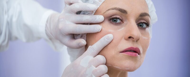 Médecin examinant le visage d'une patiente en vue d'un traitement cosmétique. meilleures cliniques de lifting en France