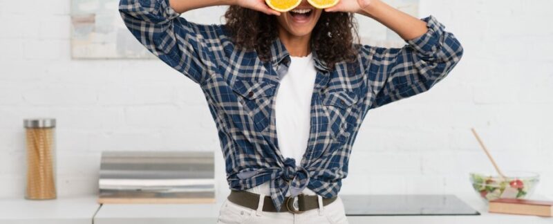 Mujer faisant des grimaces amusantes avec des oranges. meilleurs aliments aux bienfaits cachés